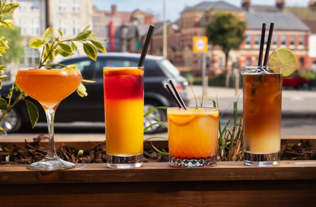 Four colourful cocktails on a ledge outside the bar