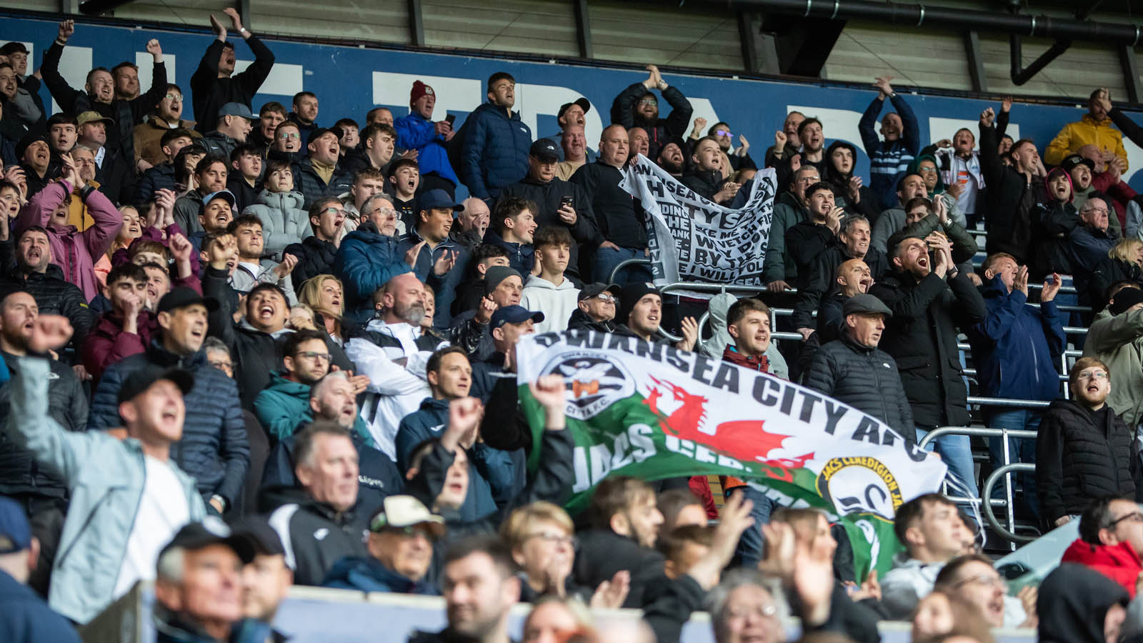 Swansea City fans celebrating in the away end