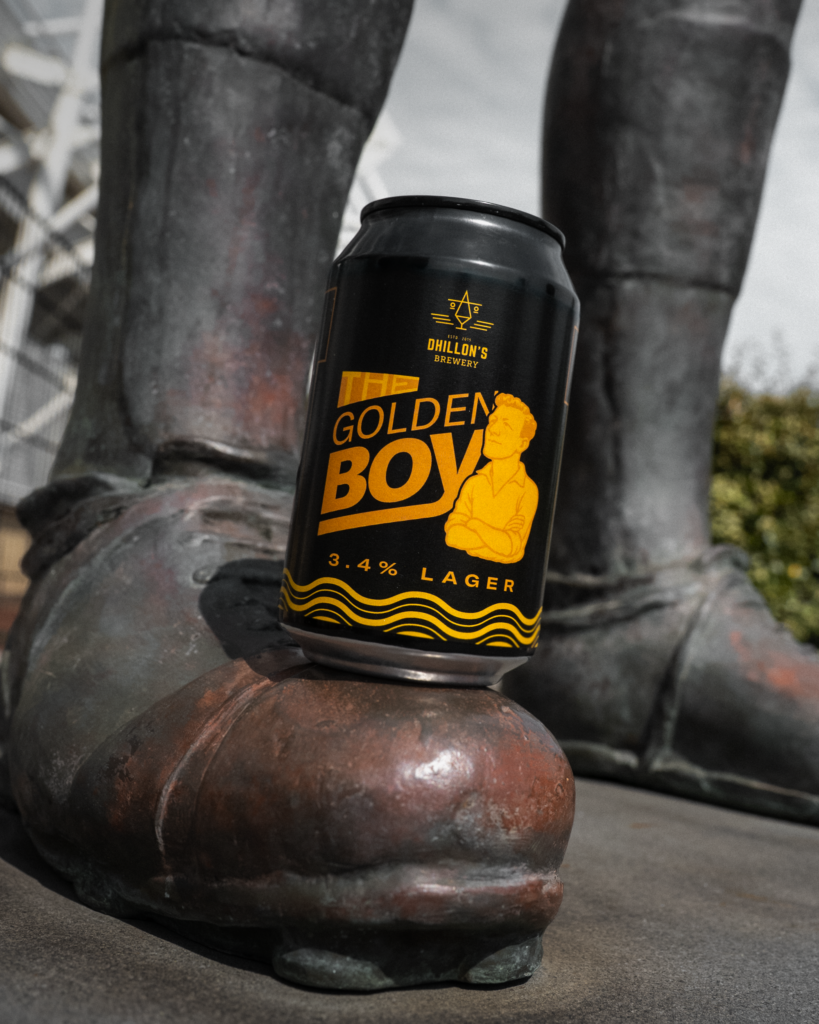 A can of The Golden Boy lager on the boot of a bronze statue